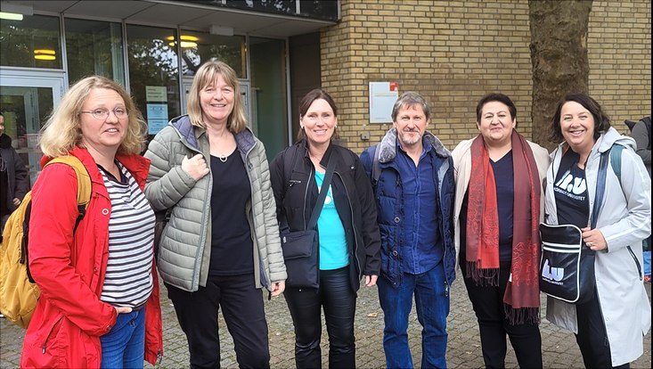 Six persons, including Dilbar Ernazarova and the Erasmus coordinators in front of the faculty building
