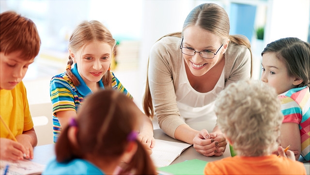 Junge Lehrerin mit Grundschülern