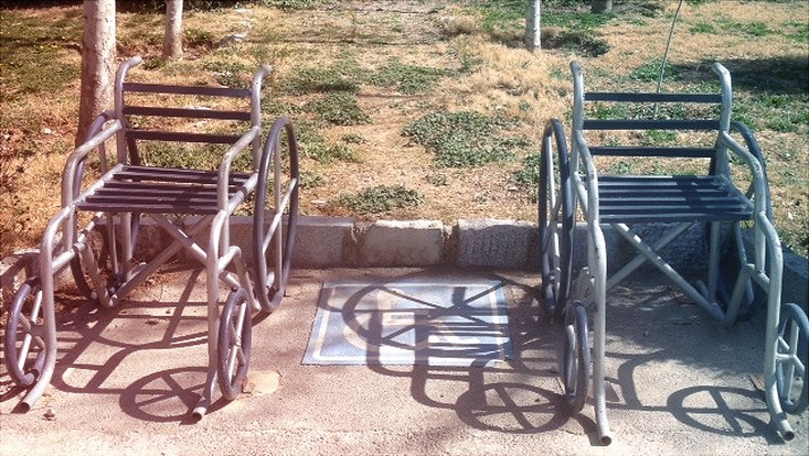 Zwei leere Rollstühle stehen auf der Straße.