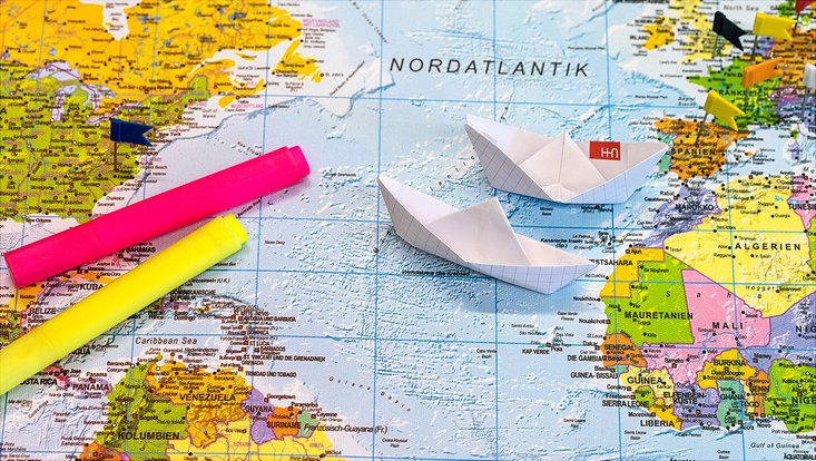 Weltkarte und Papierschiff